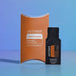 doTERRA Frankincense .25 mL black sample sachet standing beside its orange doTERRA pillow box on a glossy blue studio surface with soft reflections. doTERRA Frankincense Essential Oil Sample (.25 mL)