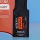 Close-up of the doTERRA On Guard Protective Blend .25 mL black sample sachet standing upright in front of its red-orange pillow box on a blue background. doTERRA On Guard Essential Oil Sample (.25 mL)