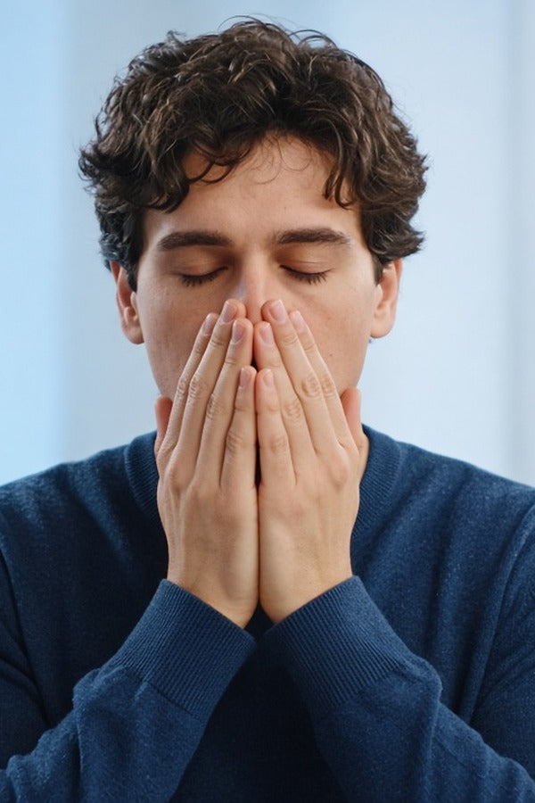 Young man at his desk inhaling doTERRA Peppermint from his cupped hands. doTERRA Peppermint Essential Oil Sample (.25 mL)