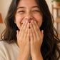 Teen girl smiling as she inhales doTERRA Wild Orange from her palms. doTERRA Wild Orange Essential Oil Sample (.25 mL)