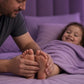Father massaging doTERRA Lavender into his toddler's feet at bedtime. doTERRA Lavender Essential Oil Sample (.25 mL)