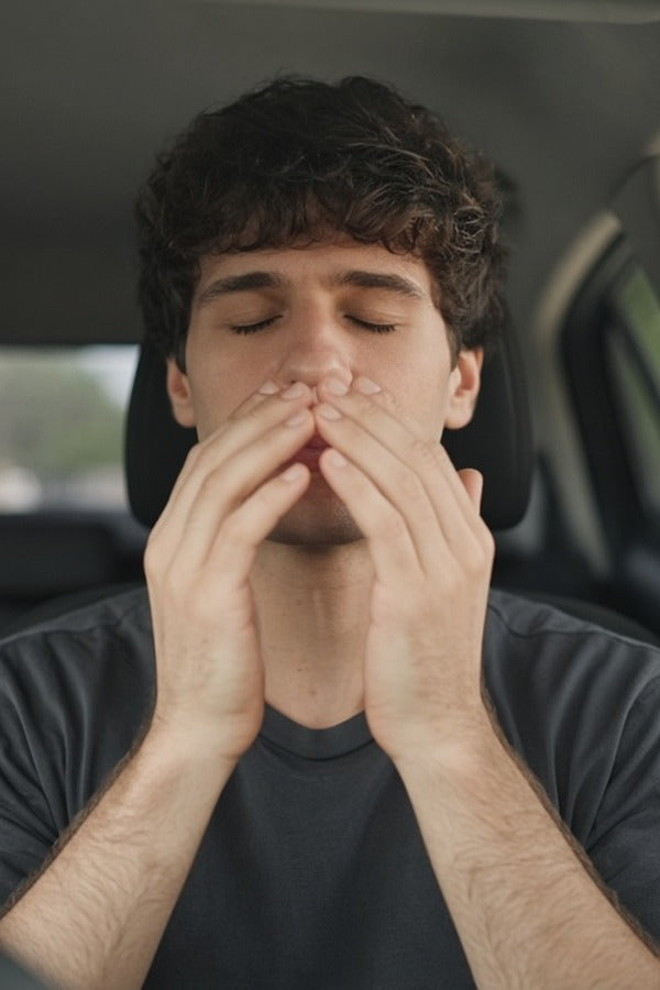 Young man in his car inhaling doTERRA Balance from his hands and wrists. doTERRA Balance Essential Oil Sample (.25 mL)