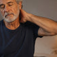 Older man rubbing doTERRA Frankincense into the back of his neck while sitting on his bed at night. doTERRA Frankincense Essential Oil Sample (.25 mL)