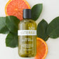 doTERRA body wash bottle with orange slices and leaves on a white background