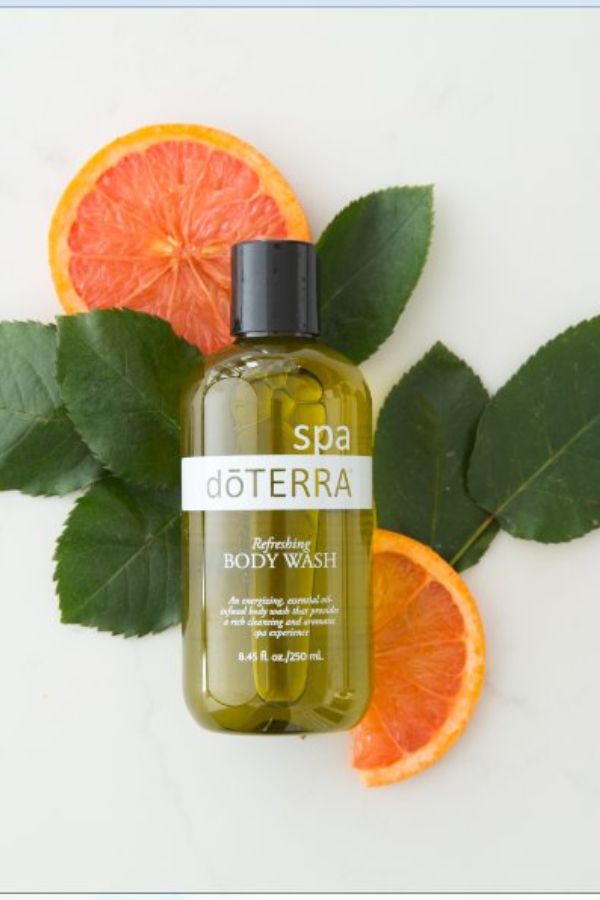 doTERRA body wash bottle with orange slices and leaves on a white background