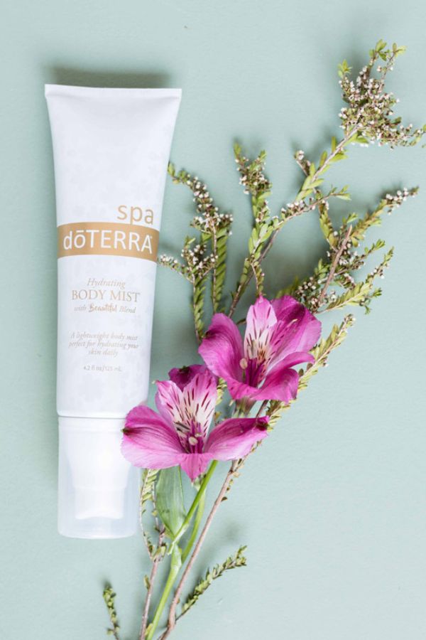 doTERRA body mist with pink flowers on a light green background