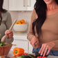 Woman preparing a fresh vegetable salad in a kitchen beside a bottle of doTERRA RevitaZen+ from the Cleanse and Restore Kit