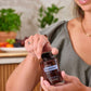 Smiling woman opening a bottle of doTERRA DigestTab Chewable Tablets in the kitchen