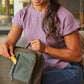 Smiling woman slipping the doTERRA InTune Stick into her backpack