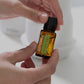 Hand holding a bottle of doTERRA Spanish Sage essential oil