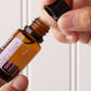 Hands opening a bottle of doTERRA Clary Sage essential oil