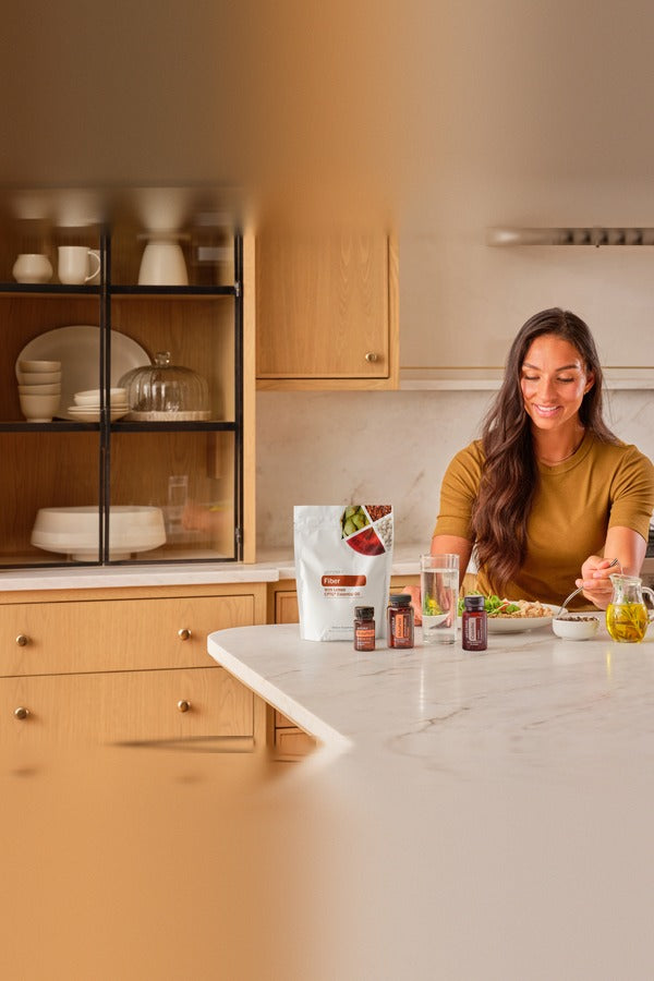 Woman preparing a healthy meal in her kitchen with the doTERRA Metabolic Health Bundle
