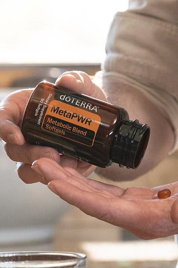 Hands holding doTERRA MetaPWR Metabolic Blend softgels