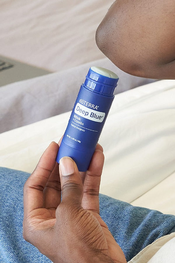 Hand holding a doTERRA Deep Blue Stick