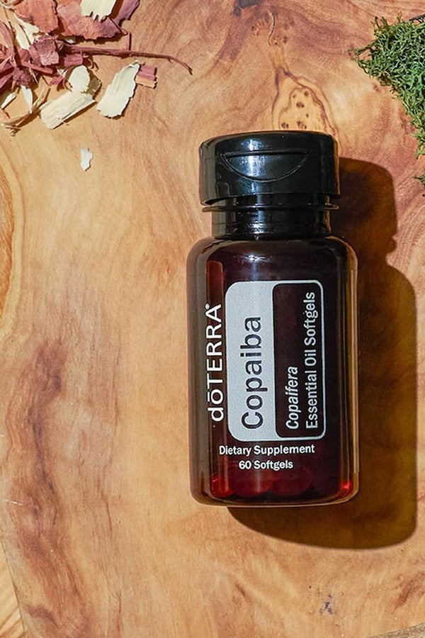 doTERRA Copaiba Softgels bottle on a wooden board