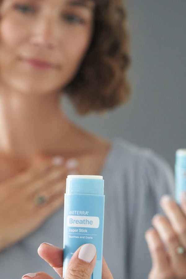 Woman applying doTERRA Breathe Vapor Stick to her chest