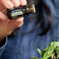 Hand adding doTERRA essential oil to a fresh salad