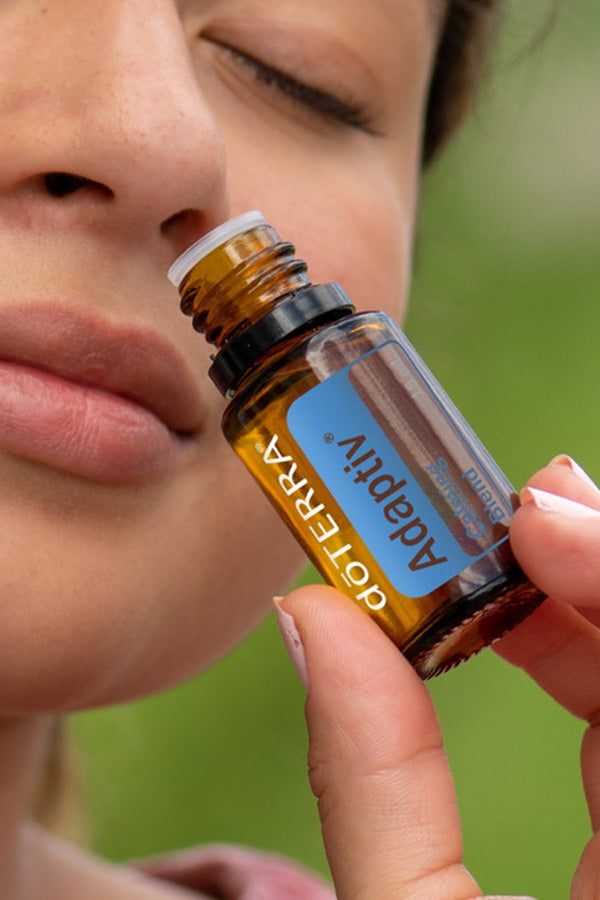 Woman inhaling the aroma of doTERRA Adaptiv Calming Blend