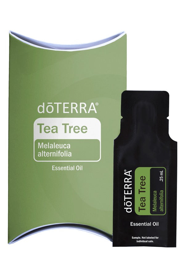 doTERRA Tea Tree .25 mL black sample sachet standing in front of its green doTERRA pillow box on a white background. doTERRA Tea Tree Essential Oil Sample (.25 mL)