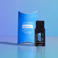 A doTERRA Adaptiv Grooming Blend essential oil blend set, featuring a blue curved box and a black single-use sachet, displayed on a reflective light blue surface against a blue gradient background. doTERRA Adaptiv Essential Oil Sample (.25 mL)