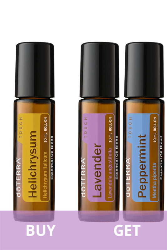 Three doTERRA Touch essential oil roll-on bottles shown side by side on a white background with a purple banner at the bottom reading BUY and GET. The bottles are amber glass with black caps, and the labels are yellow, lavender, and blue.