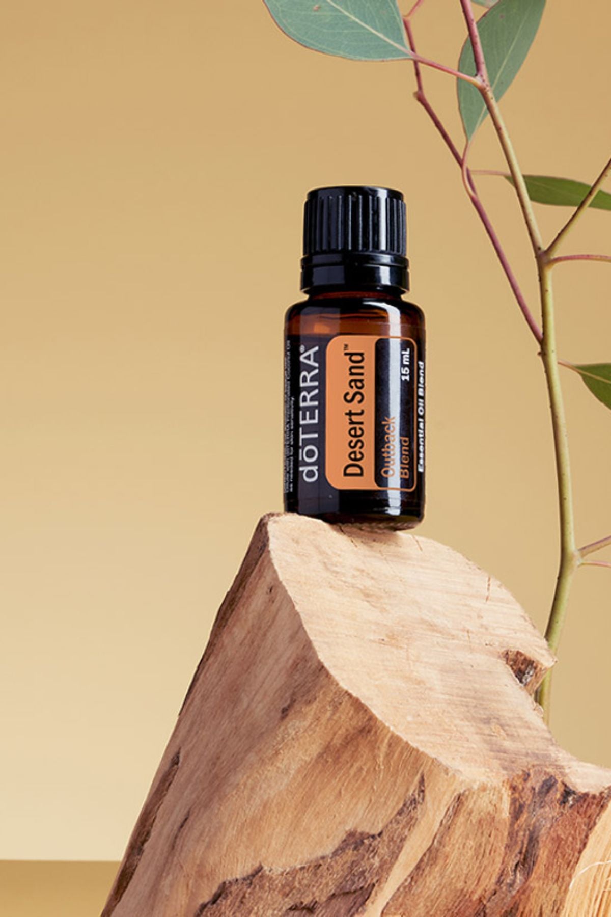 doTERRA Desert Sand essential oil bottle on a wooden surface with a natural background