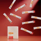 A white rectangular box labeled MegaPWT stands on a red surface, with multiple white single-serve packets floating around it against a red studio background. doTERRA MetaPWR Recharge Wild Strawberry Electrolytes