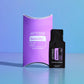 A dOTERRA Serenity Respiratory Blend essential oil blend set, featuring a purple curved box and a black single-serve packet, displayed on a reflective light blue surface against a blue gradient background. doTERRA Serenity Essential Oil Sample (.25 mL)