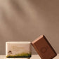 Bar of soap with packaging on a neutral background