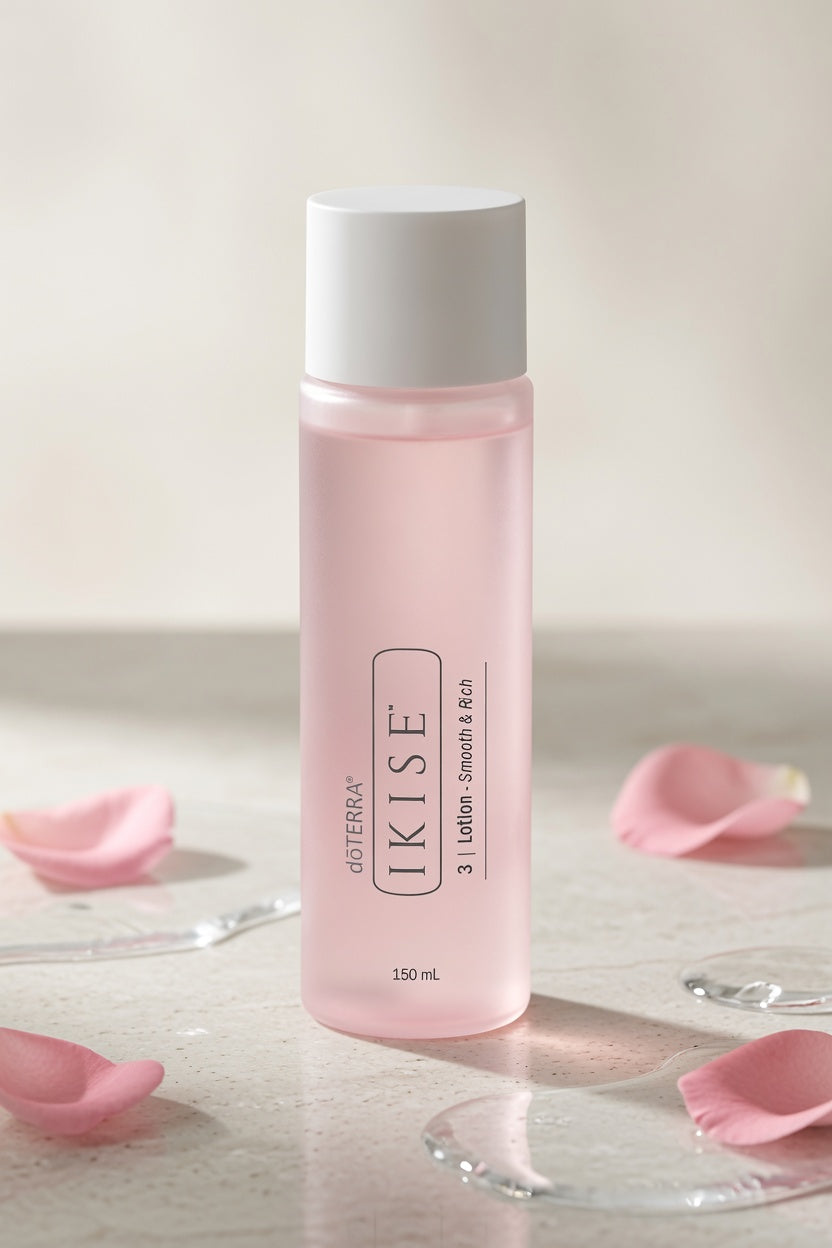 A bottle of IKISE 3 | Lotion - Smooth & Soft in a translucent light pink bottle with a white cap, styled on a light beige surface with scattered pink rose petals.