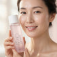 A woman holding a bottle of IKSE Skin Rescue 2.1 Toner Water, showing a clean, radiant complexion against a soft, light background.